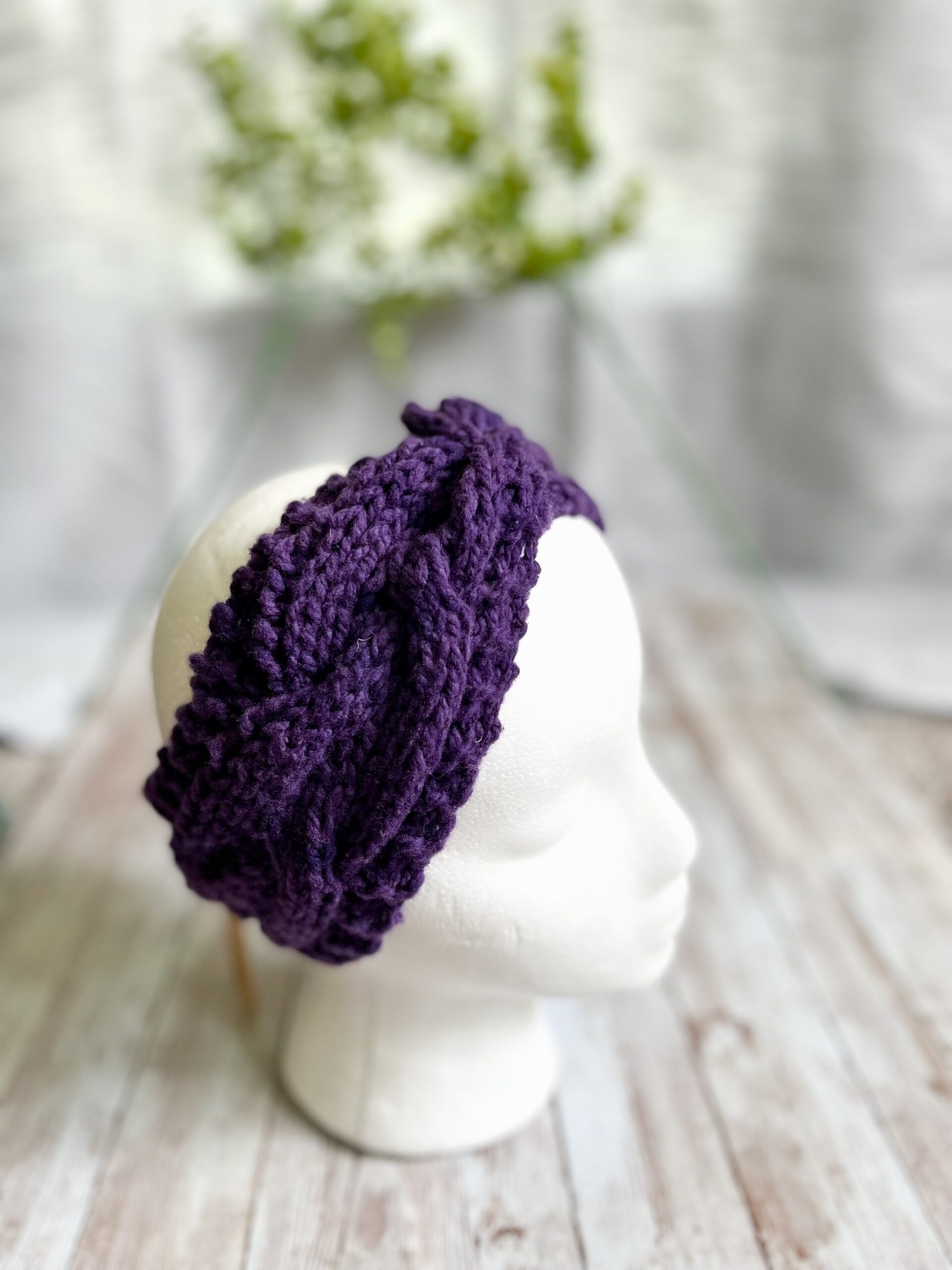 A mannequin head displays a purple hand-dyed, Virginia-raised merino cabled ear warmer