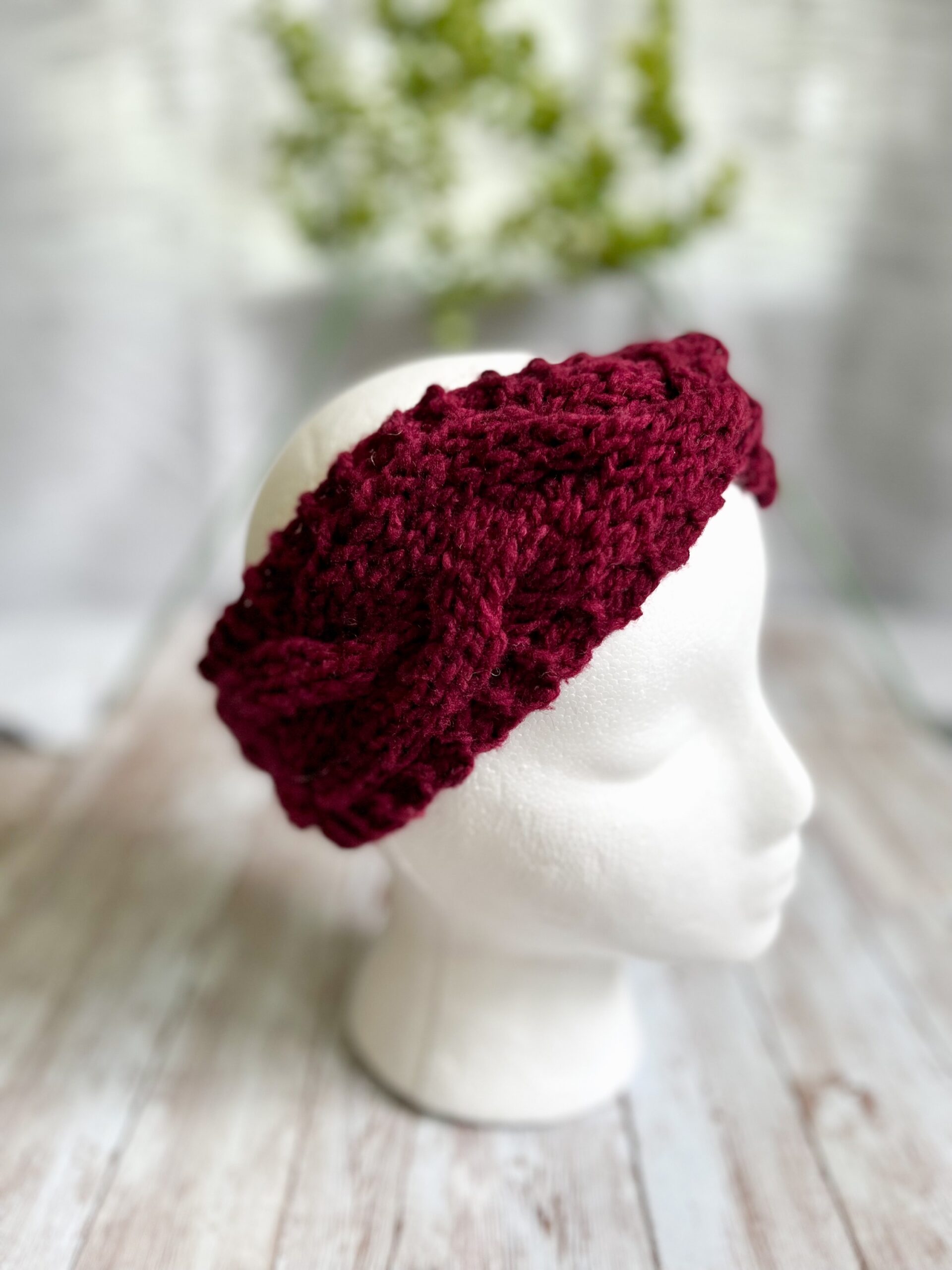 A mannequin head displays a red hand-dyed, Virginia-raised merino cabled ear warmer