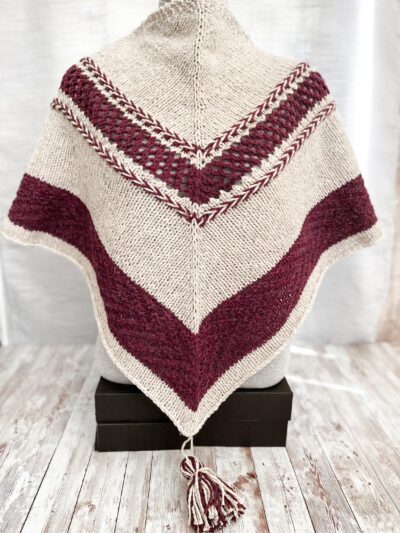A hand-knit shawl made from Virginia-farmed wool in a natural brownish gray with a mulberry accent yarn shows off braids, lace and textured stitches on a tasseled shawl.