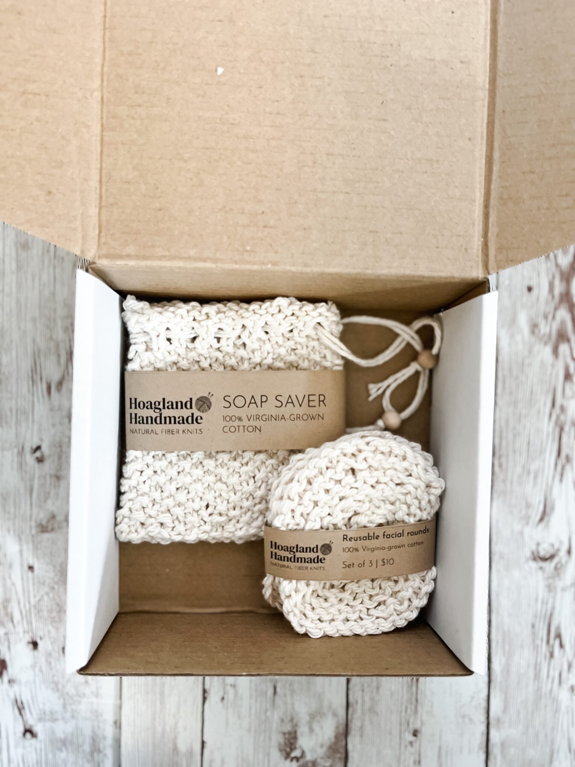 A white box contains a Virginia-grown cotton soap saver and set of reusable facial rounds.